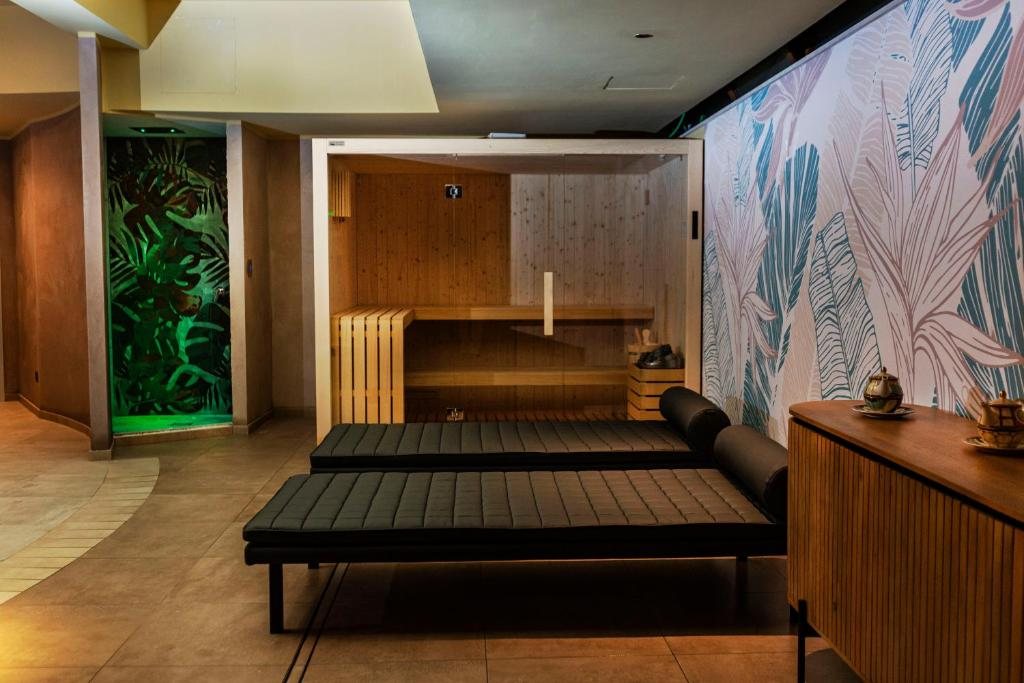 Sauna in legno con lettini relax e carta da parati a foglie