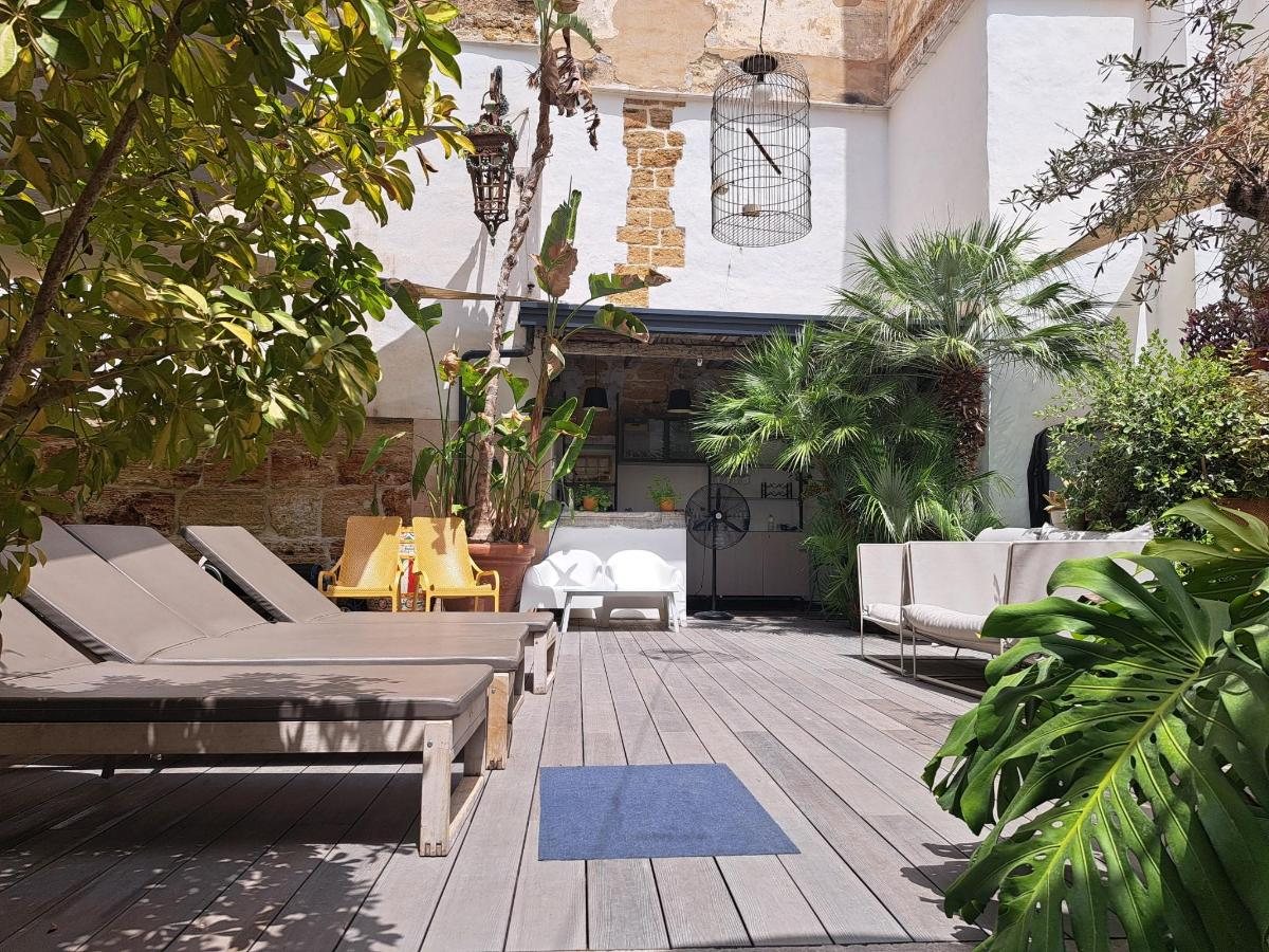 Deck in legno con lettini, palme e piante tropicali