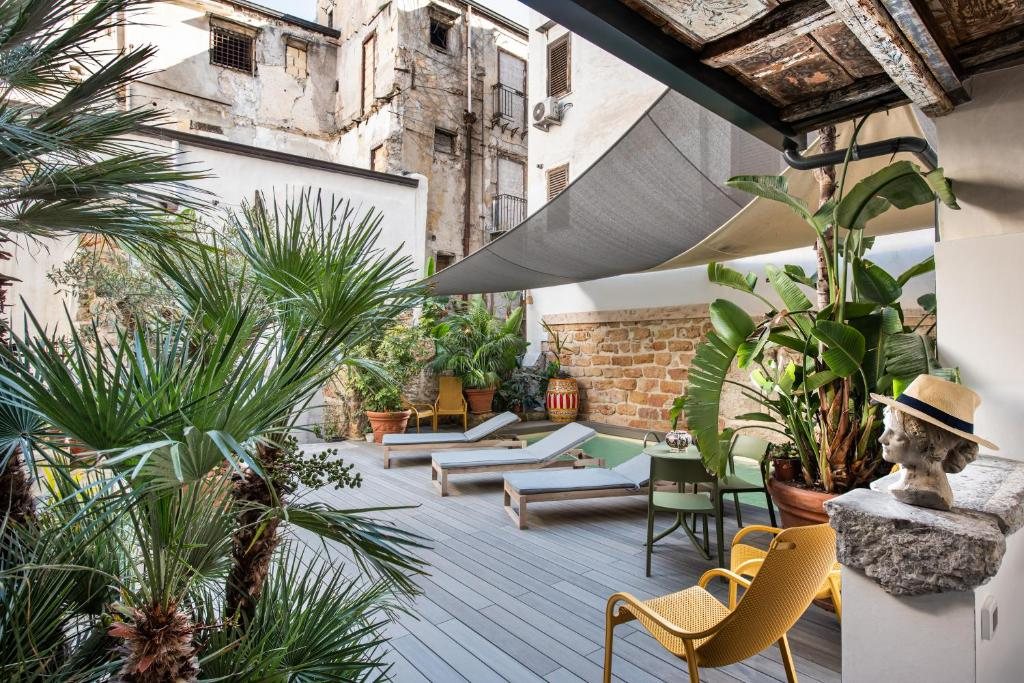 Solarium con palme, lettini e vela ombreggiante